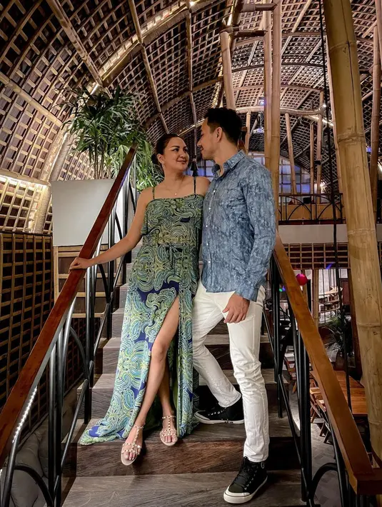 Dalam foto lainnya, terlihat Darius berpose mengenakan kemeja bermotif seperti batik bernuansa biru dengan celana jeans putih, dan sneakers hitam. Sedangkan Donna tampil lebih kasual dalam balutan gaun bernuansa biru kehijuan, tali spageti dengan high slit bermotif abstrak. Foto: Instagram.