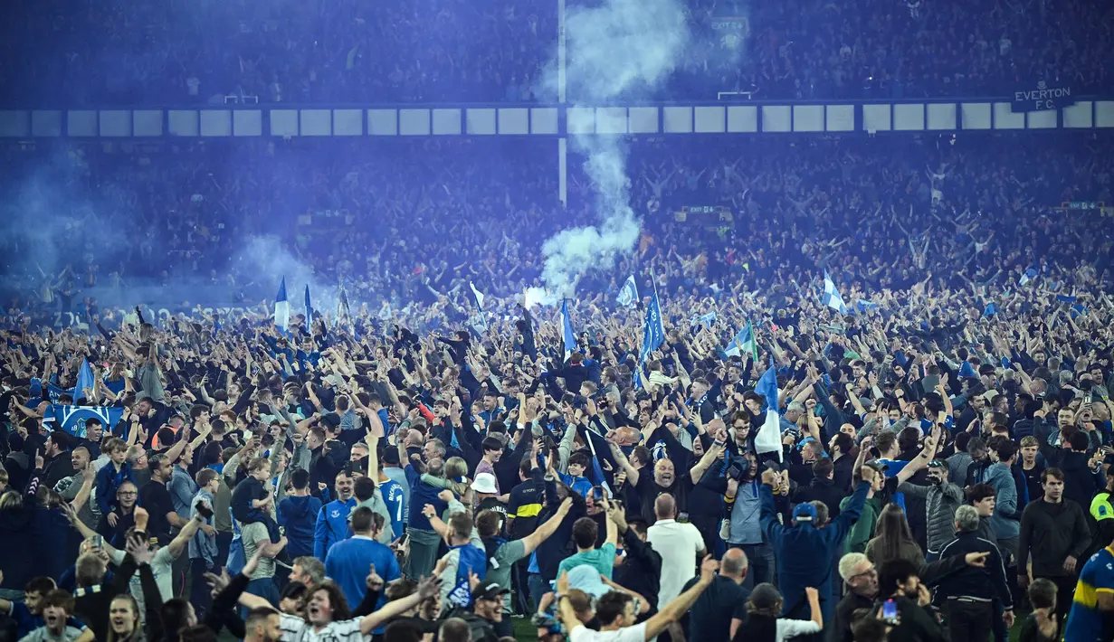 Suporter Everton menyerbu lapangan untuk merayakan akhir pertandingan Liga Inggris antara Everton dan Crystal Palace di Goodison Park di Liverpool, Inggris, 19 Mei 2022. Everton berhasil menang lewat come back dramatis 3-2 dan keluar dari zona degradasi Liga Inggris. (AFP/Oli Scarff)