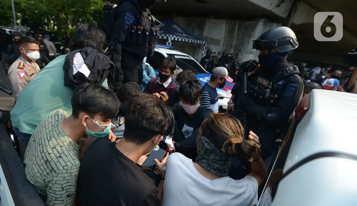 Polisi membawa pelajar yang terjaring razia saat berkumpul di sekitar Gedung DPR/MPR, Jalan Gatot Subroto, Jakarta, Rabu (7/10/2020). Puluhan pelajar diamankan sementara terkait informasi akan adanya demo dari media sosial. (merdeka.com/Imam Buhori)