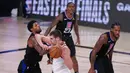 Pebasket Denver Nuggets, Nikola Jokic , berebut bola dengan pebasket Los Angeles Clippers,Paul George, pada gim ketujuh semifinal playoff NBA di Lake Buena Vista, Selasa (15/9/2020).  Nuggets menang dengan skor 104-89. (AP/Mark J. Terrill)