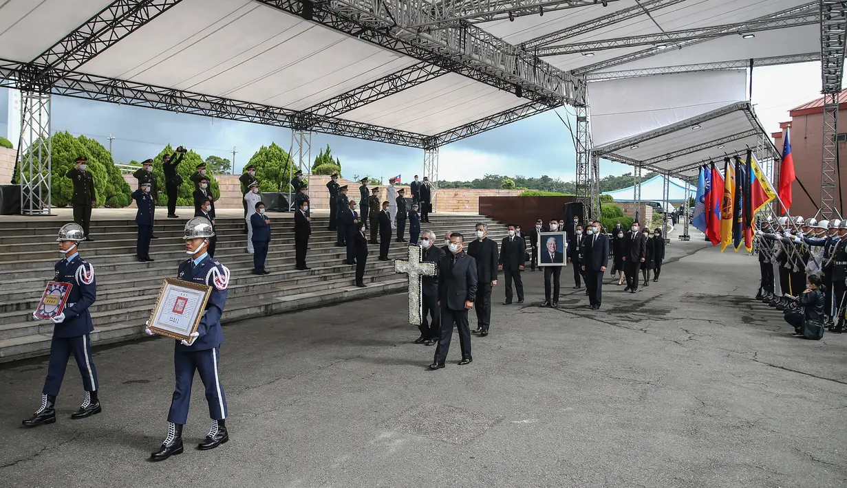 James Zhao, cucu menantu mantan Presiden Taiwan Lee Teng-hui membawa potret Lee saat prosesi pemakaman di Pemakaman Militer Wuzhi Mountain di New Taipei City, Rabu (7/10/2020). Lee, yang dianggap sebagai "bapak demokrasi Taiwan", meninggal Juli lalu di usia 97 tahun. (Military News Agency via AP)