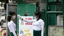 Seorang guru mengenakan masker mengukur suhu tubuh siswa di gerbang sekolah saat hari pendaftaran sekolah di Yangon, Myanmar  (13/7/2020). Myanmar sejak Selasa (7/7) memulai pendaftaran sekolah untuk tahun ajaran 2020-2021, yang tertunda akibat pandemi COVID-19. (Xinhua/U Aung)