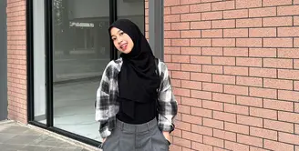 Padu padan plaid shirt dengan top hitam dan loose pants abu-abu sempurna untuk outfit kuliah.  [Instagram/adiba.knza]