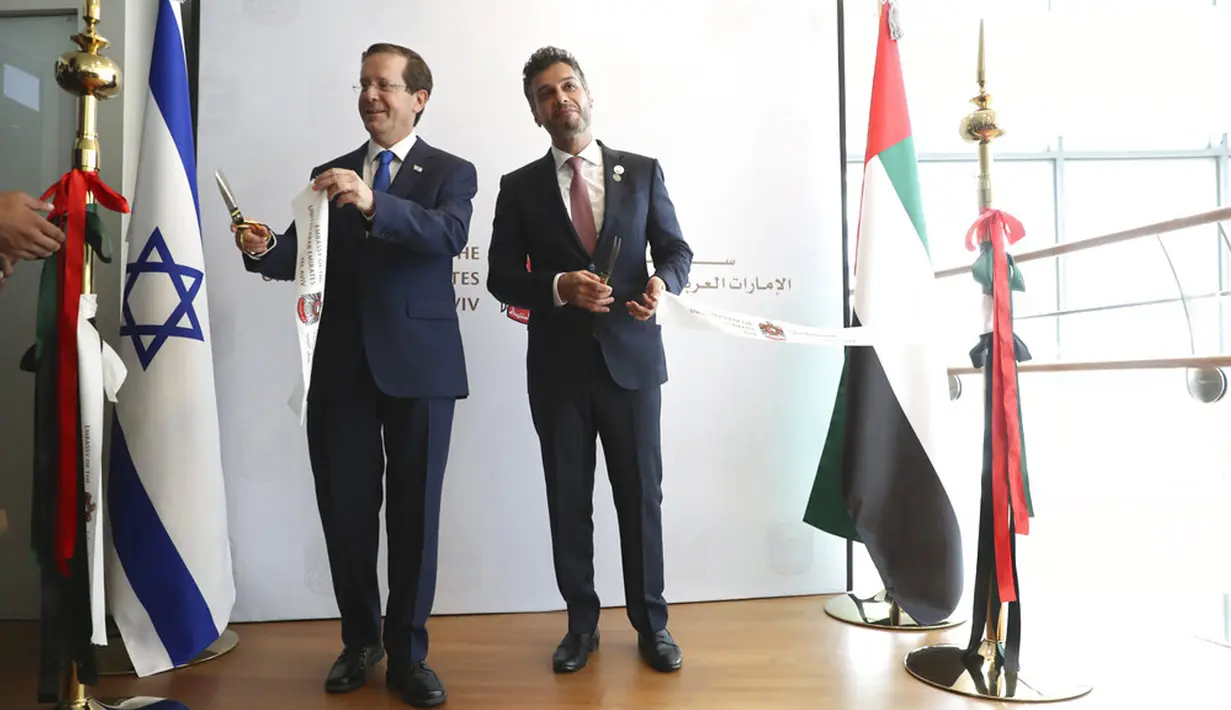 Presiden Israel Isaac Herzog (kiri) memotong pita dengan Duta Besar Uni Emirat Arab (UEA) untuk Israel Mohamed Al Khaja saat upacara pembukaan Kedutaan Besar UEA di Tel Aviv, Israel, Rabu (14/7/2021). UEA secara resmi membuka kedutaannya di Israel. (AP Photo/Ariel Schalit)