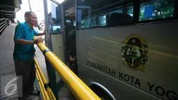 Petugas saat akan menutup pintu bus shelter yang melintasi Jl. Malioboro, Yogyakarta, Selasa (5/4). Bus digunakan untuk mengangkut pejalan kaki yang memarkir kendaraan di Taman Parkir Abu Bakar Ali.  (Liputan6.com/Boy Harjanto)