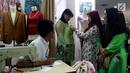 Pelanggan mencoba baju pesanannya yang dijahit di Pasar Mayestik, Jakarta Selatan, Senin (11/6). Masyarakat mulai membeli dan membuat baju pilihan mereka jelang Lebaran. (Liputan6.com/JohanTallo)