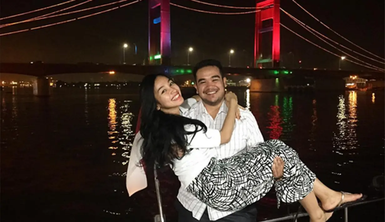 Mereka selfi dengan latar belakang panorama Jembatan Ampera. Asyraf terlihat membopong Tya. Mereka kompak mengumbar senyum. (Via Instagram/@tyaarifinnw)