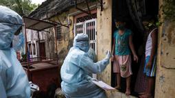 Petugas kesehatan India yang mengenakan alat pelindung diri melakukan pemeriksaan COVID-19 di kawasaan permukiman kumuh di tengah penyebaran wabah tersebut di Mumbai, India (17/6/2020). (Xinhua/Stringer)