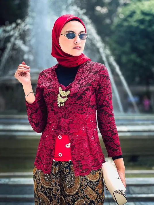 <p>Zee Zee Shahab memamerkan gayanya pakai kebaya brokat klasik berwarna merah. Padu padan inner hitam, korset jumputan merah, kain batik sebagai rok, dan hijab merah polos menambah kesan keren pada keseluruhan penampilan Zee Zee Shahab di sini. [Foto: Instagram/zeezeeshahab]</p>