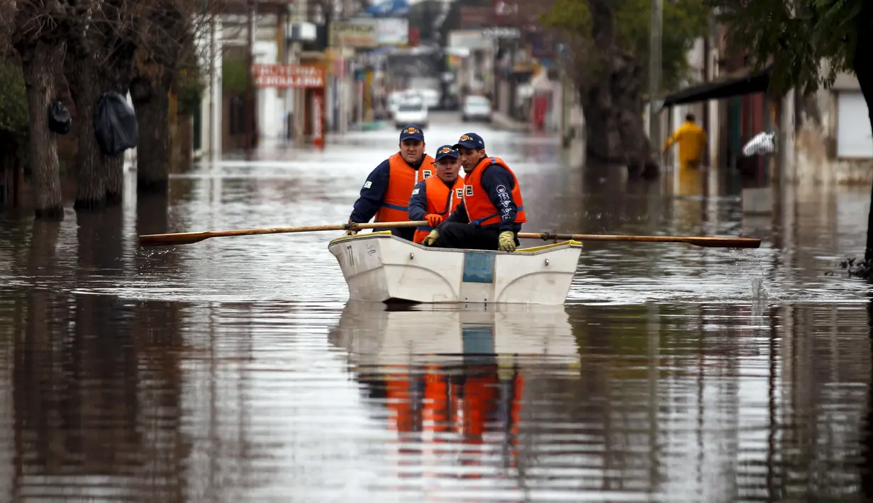 Petugas penyelamat berpatroli mengelilingi daerah banjir di daerah Lujan, Argentina, Rabu (12/8/2015).  Lebih dari 20.000 orang telah dievakuasi setelah hujan lebat di akhir pekan lalu yang menyebabkan sungai naik dan banjir. (REUTERS/Marcos Brindicci)