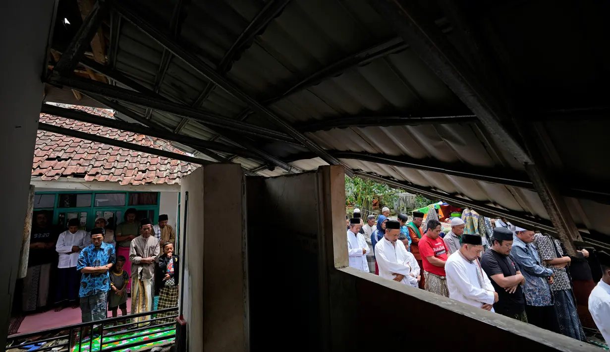 Umat muslim melaksanakan salat Jumat di luar masjid yang rusak parah akibat gempa di Desa Gasol, Cianjur, Jawa Barat, Indonesia, Jumat (25/11/2022). Gempa dengan magnitudo 5,6 yang mengguncang Cianjur pada 21 November 2022 lalu telah menewaskan 272 orang, 2.046 orang luka-luka, dan sebanyak 62.545 orang mengungsi. (AP Photo/Achmad Ibrahim)