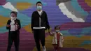 Sebuah keluarga mengenakan masker untuk mengekang penyebaran COVID-19 di Beijing, China, Minggu (11/10/2020). Meski penyebaran COVID-19 hampir diberantas di China, pandemi masih melonjak di seluruh dunia dengan jumlah kematian yang terus meningkat. (AP Photo/Andy Wong)