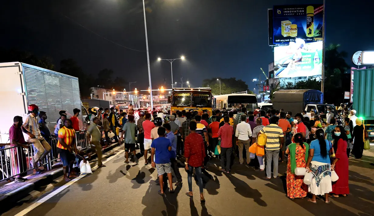 Warga berkumpul di pompa bensin untuk membeli minyak tanah di Kolombo (22/3/2022). Sri Lanka memerintahkan pasukan ke pompa bensin pada 22 Maret ketika protes sporadis meletus di antara ribuan pengendara yang mengantre setiap hari untuk mendapatkan bahan bakar yang langka. (AFP/Ishara S.Kodikara)