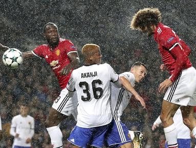 Sundulan pemain Manchester United, Marouane Fellaini (kanan) menembus pertahanan pemain Basel pada laga grup A Liga Champions di Old Trafford, Manchester, (12/9/2017). MU menang 3-0. (Martin Rickett/PA via AP)