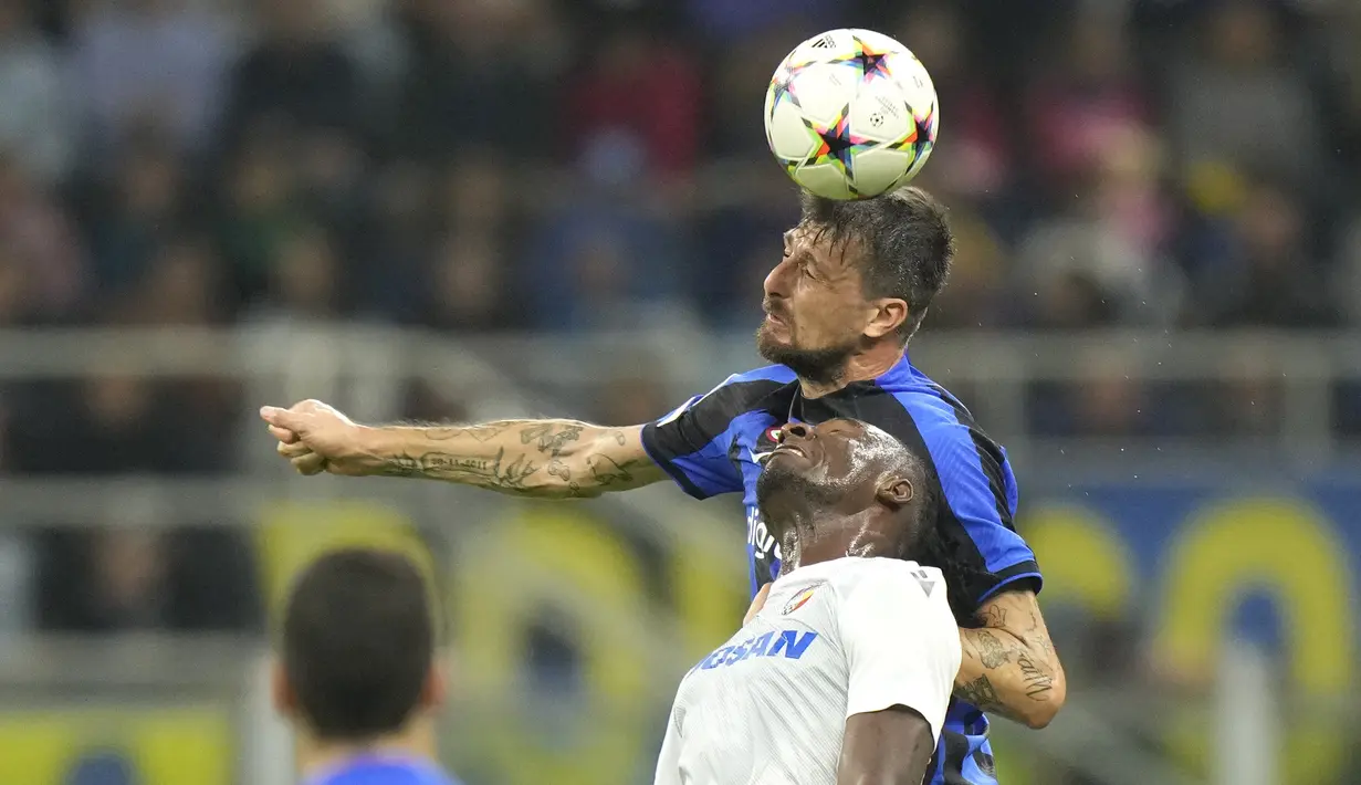 Bek Inter Milan  Francesco Acerbi berebut bola dengan penyerang Fortune Bassey pada laga matchday 5 Grup C Liga Champions 2022/2023 di Giuseppe Meazza, Kamis (27/10/2022) dini hari WIB. Kemenangan skuad asuhan Simone Inzaghi sekaligus memastikan Barcelona tersingkir ke Liga Europa. (AP Photo/Luca Bruno)