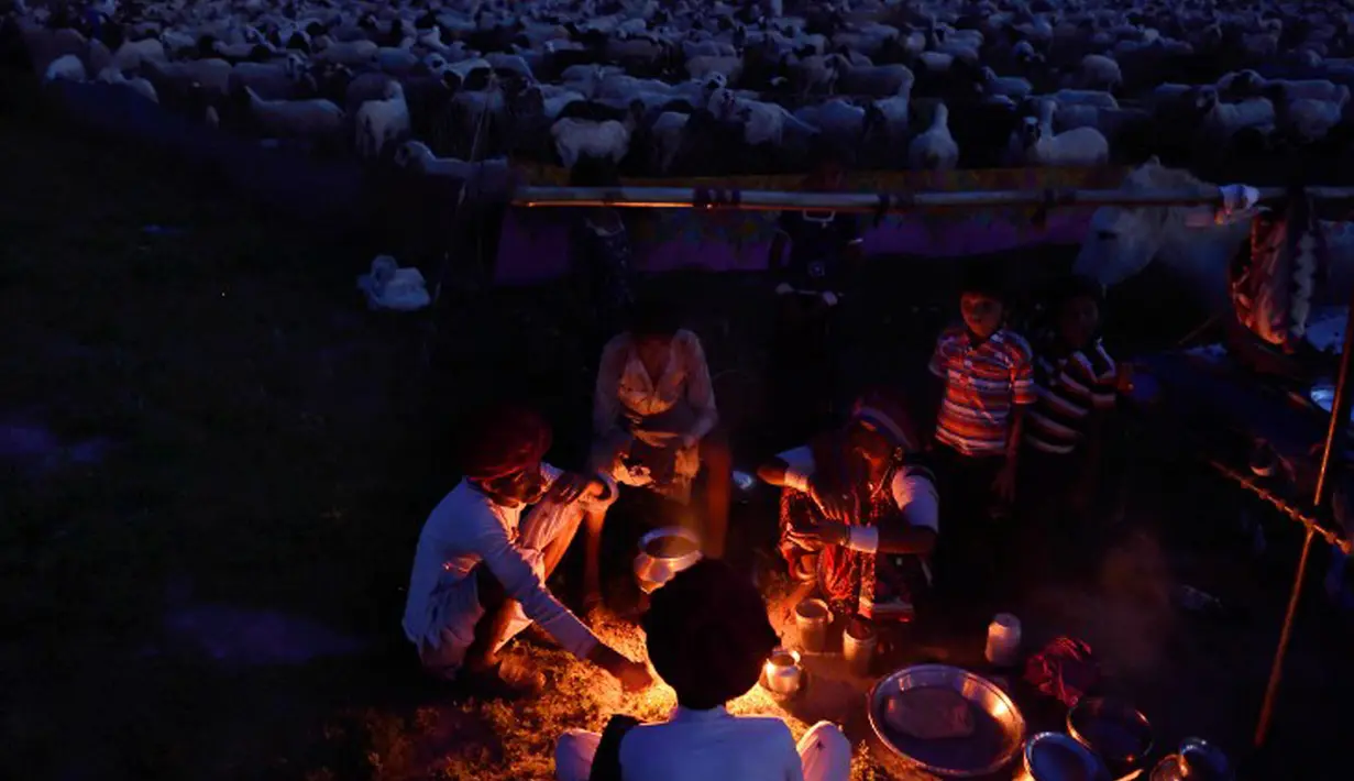 Penggembala menyiapkan makanan di kamp mereka di distrik Faridabad, New Delhi, 24 Maret 2015. Sebuah penelitian baru dari PBB memprediksi bahwa India akan melampaui China sebagai negara dengan penduduk terbanyak pada tahun 2022. (AFP PHOTO/MONEY SHARMA)