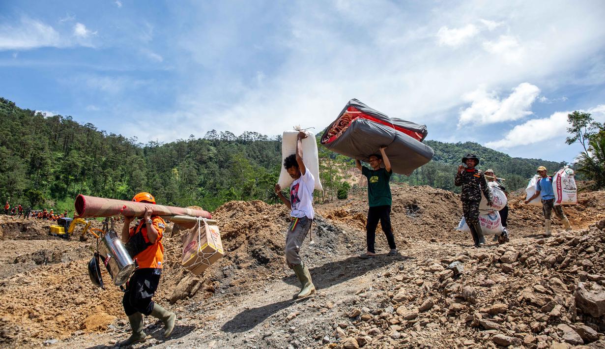 Kondisi tersebut dinilai terlalu berbahaya bagi keselamatan tim pencari dan penyelamat gabungan. Tampak dalam foto, warga dan relawan penyelamat membawa barang-barang yang diselamatkan di lokasi longsor di Desa Situkung, Kecamatan Pandanarum, Kabupaten Banjarnegara, Jawa Tengah, pada Rabu 19 November 2025. (DEVI RAHMAN/AFP)