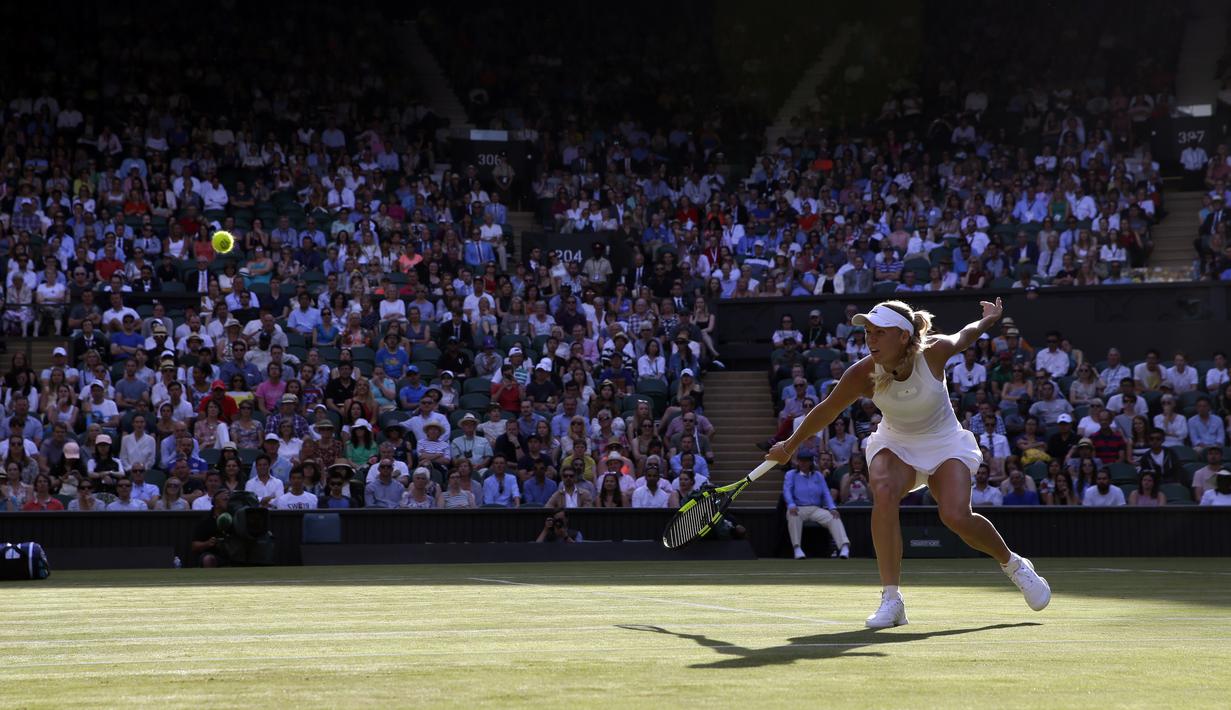 Aksi Caroline Wozniacki saat mengembalikan bola ke arah Timea Babos pada laga tunggal putri Wimbledon 2017 di Wimbledon Tennis Championships, London, (4/7/2017). Wozniacki menang 6-4, 4-6, 6-1. (AP/Alastair Grant)