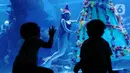 Anak-anak menyaksikan penyelam berkostum putri duyung di dalam air yang dihiasi pohon natal di Jakarta Aquarium dan Safari, Mal Neo Soho, Grogol, Jakarta, Kamias (24/12/2020). Pertunjukan tersebut untuk mengisi libur Natal dan Tahun Baru 2021. (Liputan6.com/Angga Yuniar)