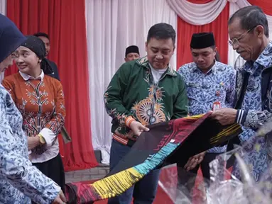 Kepala Departemen Komunikasi Perusahaan Semen Indonesia Sigit Wahono (tengah) bersama Bupati Magetan Suprawoto (kanan) mengamati batik ciprat karya siswa SMA/SMK/MA yang dipamerkan dalam acara #MembangunKemandirian di SMAN 1 Magetan Jawa Timur (2/5/2019). (Liputan6.com/HO/Eko)