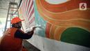Petugas PPSU melukis mural dengan warna-warna cerah sehingga kolong Semanggi terlihat lebih cerah. Liputan6.com/Faizal Fanani)