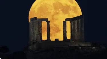 Bulan purnama terbesar atau supermoon muncul di belakang Kuil Poseidon di Tanjung Sounio, selatan Athena, Senin (19/8/2024). (AP Photo/Michael Varaklas)