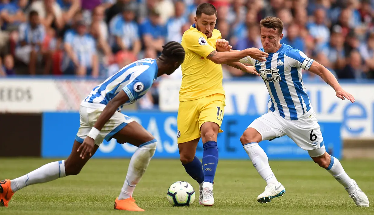 Gelandang Chelsea, Eden Hazard, berusaha melewati pemain Huddersfield Town pada laga Premier League di Stadion John Smith's, Sabtu (11/8/2018). Chelsea menang 3-0 atas Huddersfield Town. (AFP/Oli Scarff)
