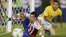 Gelandang Paraguay, Edgar Benitez, terjatuh berebut bola dengan bek Brasil, Dani Alves, pada kualifikasi Piala Dunia 2018 di Stadiom Chaco, Paraguay, Rabu (30/3/2016). Kedua tim bermain imbang 2-2. (Reuters/Jorge Adorno)