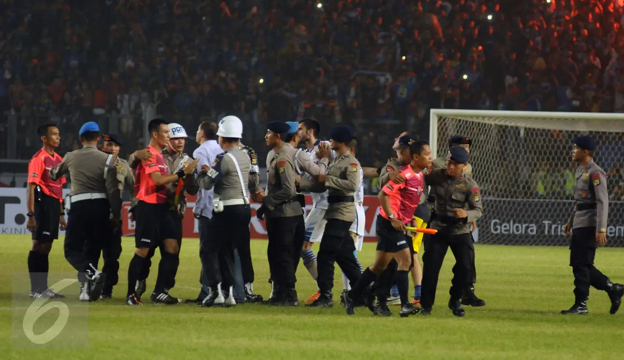 Personel kepolisian mengamankan wasit usai laga final Piala Bhayangkara 2016 antara Arema Cronus vs Persib di Stadion GBK Jakarta, Minggu (3/4/2016). Laga diwarnai aksi protes dari suporter dan official Persib. (Liputan6.com/Helmi Fithriansyah)