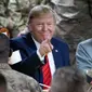 Presiden Amerika Serikat Donald Trump menunjuk sambil makan bersama para tentara di Pangkalan Udara Bagram, Afghanistan, Kamis (28/11/2019). Kunjungan dadakan Trump pada hari Thanksgiving tersebut mengejutkan pasukan AS yang bertugas di Afghanistan. (AP Photo/Alex Brandon)