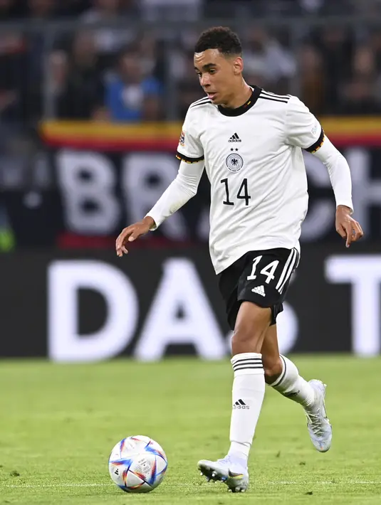 Pemain Jerman, Jamal Musiala membawa bola saat bertanding melawan Inggris pada pertandingan Grup A3 UEFA Nations League di Allianz Arena, Munich, Rabu (8/6/2022). Inggris bermain imbang dengan Jerman 1-1. (AP Photo/Markus Ulmer)