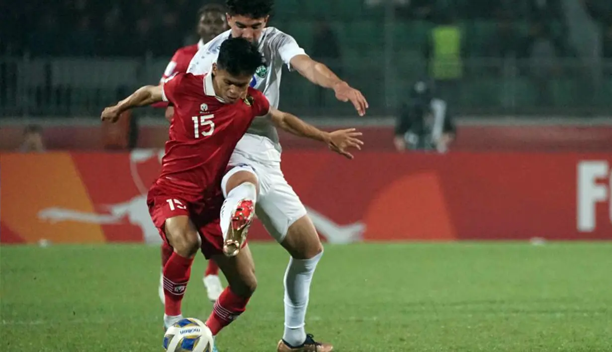 Pemain belakang timnas Indonesia U-20, Dzaky Asraf (kiri) berebut bola dengan pemain Uzbekistan pada laga terakhir Grup A Piala Asia U-20 di Stadion Istiqlol Fergana, Uzbekistan, Selasa (7/3/2023). Garuda Muda gagal mencetak gol dalam laga yang tuntas 0-0. Hasil ini membuat Indonesia tersingkir dari ajang Piala Asia U-20. (Foto: Dok PSSI)