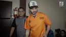 Aktor Fachri Albar dikawal petugas saat dihadirkan dalam gelar rilis di Polres Jakarta Selatan, Rabu (14/2). Selain itu ditemukan juga puntung ganja bekas pakai. (Liputan6.com/Faizal Fanani)