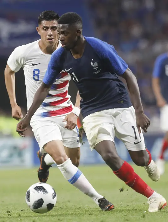 Aksi pemain Prancis, Ousmane Dembele (kanan) melewati adangan pemain Amerika, Joe Corona pada laga uji coba di Groupama stadium, Decines, Lyon (9/6/2018). Prancis dan Amerika bermain imbang 1-1. (AP/Laurent Cipriani)