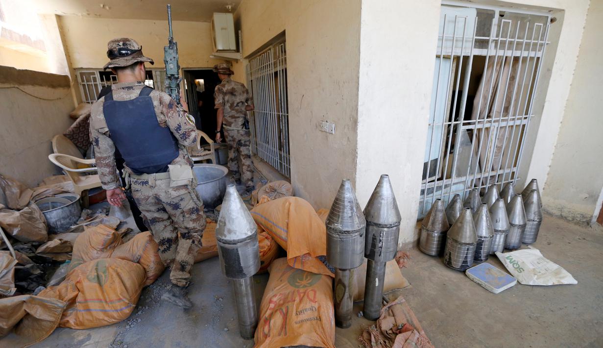 Anggota pasukan kontraterorisme Irak memeriksa bangunan yang digunakan sebagai pabrik senjata militan ISIS yang berhasil ditemukan di Fallujah, Irak, Kamis (23/6). (REUTERS/Thaier Al-Sudani)