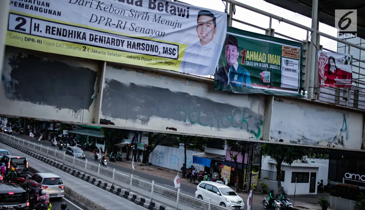Alat peraga kampanye (APK) terpasang di jembatan penyeberangan orang (JPO) kawasan Mampang, Jakarta, Rabu (27/2). APK masih menghiasi JPO di Ibu Kota meski KPU telah melarang pemasangan di sarana dan prasarana publik. (Liputan6.com/Faizal Fanani)