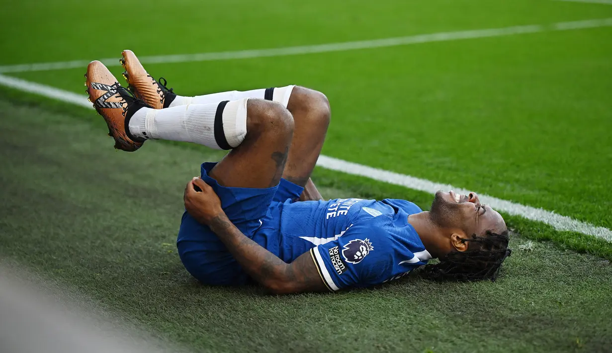 Pemain Chelsea, Raheem Sterling, meringis kesakitan setelah dilanggar pemain Burnley, Vitinho, pada laga pekan ke-8 Premier League 2023/2024 di Stadion Turf Moor, Sabtu, (7/10/2023). (AFP/Oli Scarff)