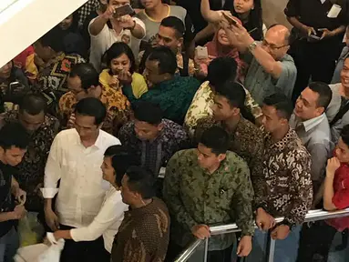 Para pengunjung mal menghampiri Presiden Joko Widodo saat berada di pusat perbelanjaan Pondok Indah Mall, Jakarta Selatan, Minggu (20/11). Ramai-ramai para pengunjung meminta kesempatan untuk berfoto bersama dengan Jokowi.(Dok. Paspampres)
