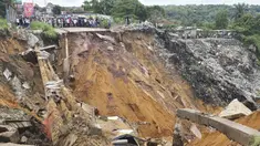 Permukaan jalan ambruk oleh tanah longsor yang disebabkan hujan lebat melanda distrik Lemba, Kinshasa di Republik Demokratik Kongo pada Selasa (26/11/2019). Musibah tersebut telah mengakibatkan jalan raya yang menjadi penghubung antar desa putus total. (AFP/Ange Kasongo)