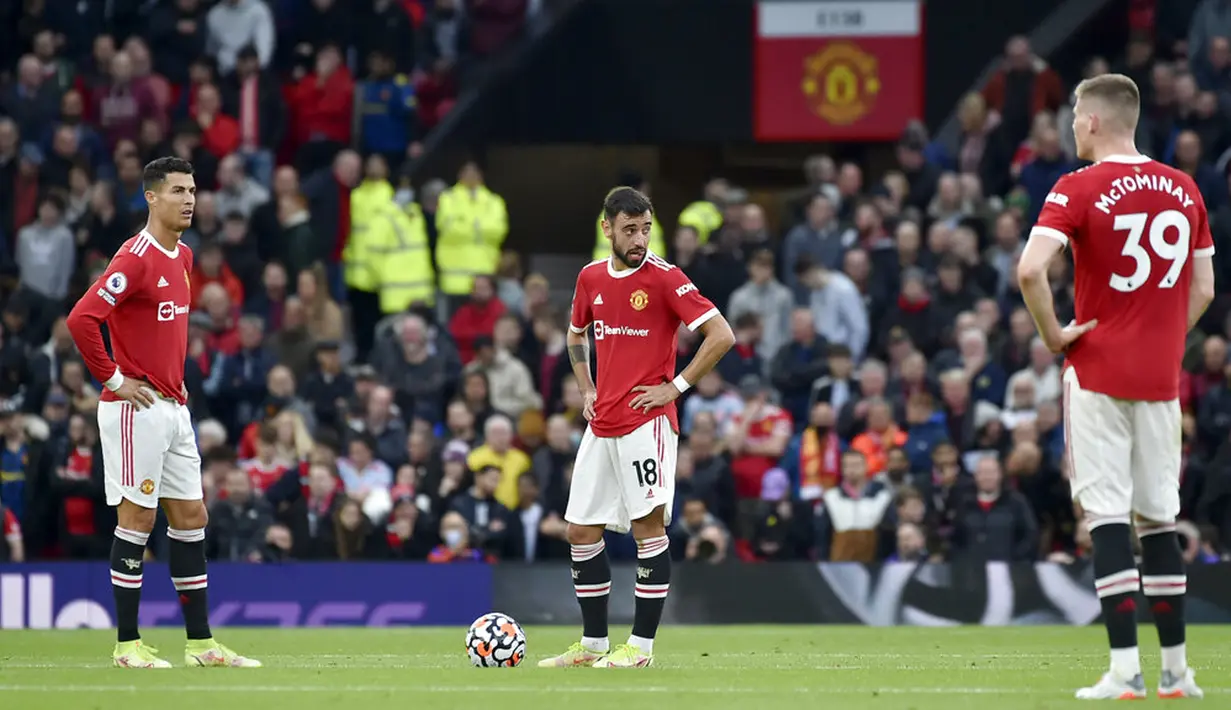 Pemain Manchester United Cristiano Ronaldo (kiri) dan Bruno Fernandes (tengah) bereaksi setelah pemain Liverpool Mohamed Salah mencetak gol ke gawang mereka pada pertandingan Liga Inggris di Old Trafford, Manchester, Inggris, Minggu (24/10/2021). Liverpool menang 5-0. (AP Photo/Rui Vieira)