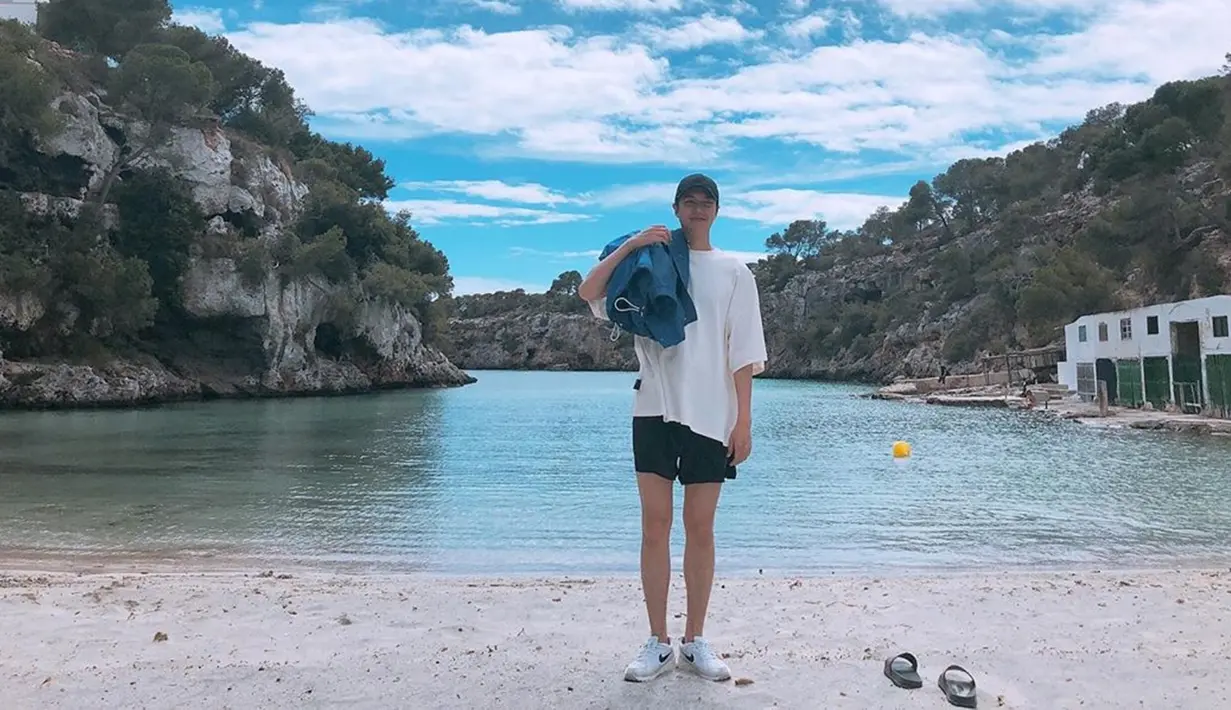 Pria yang pernah bermain dalam drama The Heirs saat liburan di pantai juga terlihat santai. Ia memilih untuk mengenakan kaus oversized berwarna putih yang dipadukan celana pendek serta topi hitam. (Liputan6.com/IG/@actorleeminho)