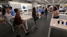 Para karyawan menyambut pelanggan yang memasuki toko mereka yang menjual Apple iPhone 16 di Jakarta pada 11 April 2025. (BAY ISMOYO/AFP)