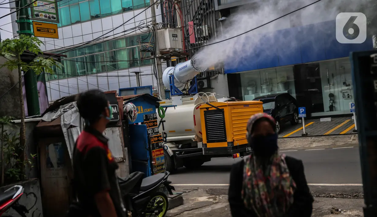 Petugas PMI dengan mobil gunners spraying menyemprotkan cairan disinfektan di kawasan Jalan Blok A, Jakarta, Kamis (30/4/2020). Untuk mencegah penyebaran COVID-19, PMI melakukan penyemprotan disinfektan berskala besar di wilayah DKI dengan memanfaatkan momen PSBB. (Liputan6.com/Faizal Fanani)