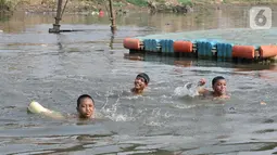 Anak-anak berenang di Kanal Banjir Barat, Jakarta, Minggu (3/11/2019). Mereka memilih berenang di Kanal Banjir Barat karena minimnya fasilitas bermain di kawasan tersebut. (merdeka.com/Iqbal Nugroho)