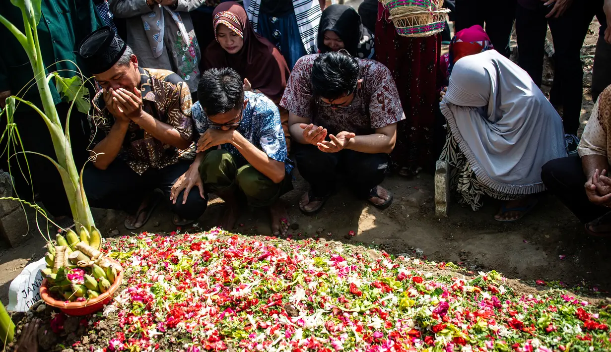 Keluarga berdoa bersama saat pemakaman korban jatuhnya pesawat Lion Air JT 610 Jannatun Cintya Dewi di Sidoarjo, Jawa Timur, Kamis (1/11/2018). Jannatun merupakan pegawai Kementerian ESDM yang menjadi salah satu penumpang Lion Air. (JUNI KRISWANTO / AFP)
