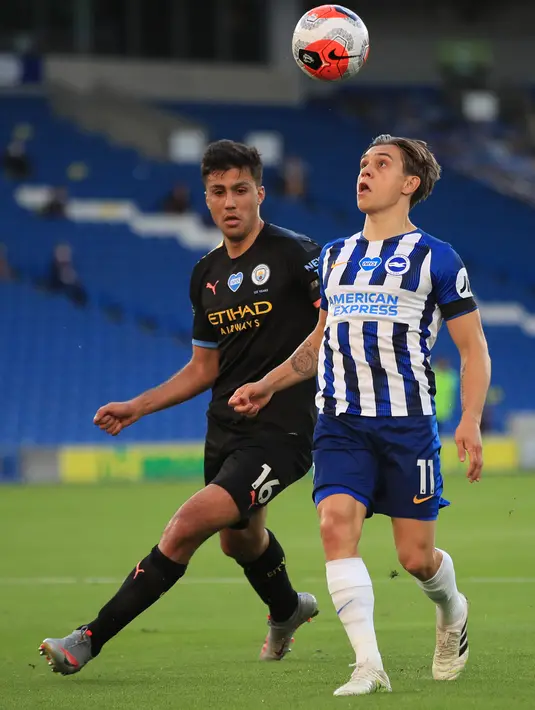 Pemain tengah Manchester City, Rodri (kiri) berebut bola dengan pemain tengah Brighton and Hove Albion, Leandro Trossard pada Pekan ke-35 Liga Inggris di stadion The American Express, Minggu (12/7/2020). Manchester City berpesta gol di markas Brighton. (Adam Davy / POOL / AFP)