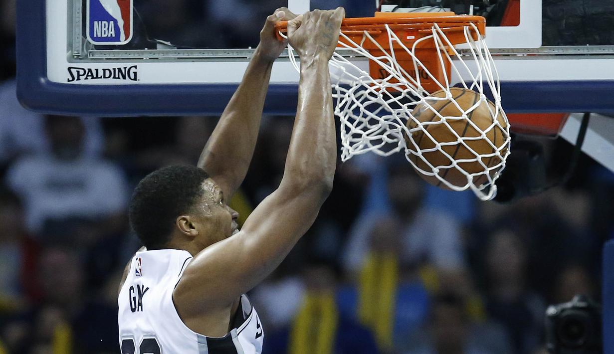 Pebasket San Antonio Spurs, Rudy Gay, memasukan bola saat pertandingan melawan Oklahoma City Thunder pada laga NBA di Chesapeake Energy Arena, Minggu (11/3/2018). Thunder menang 104-94 atas Spurs. (AP/Sue Ogrocki)