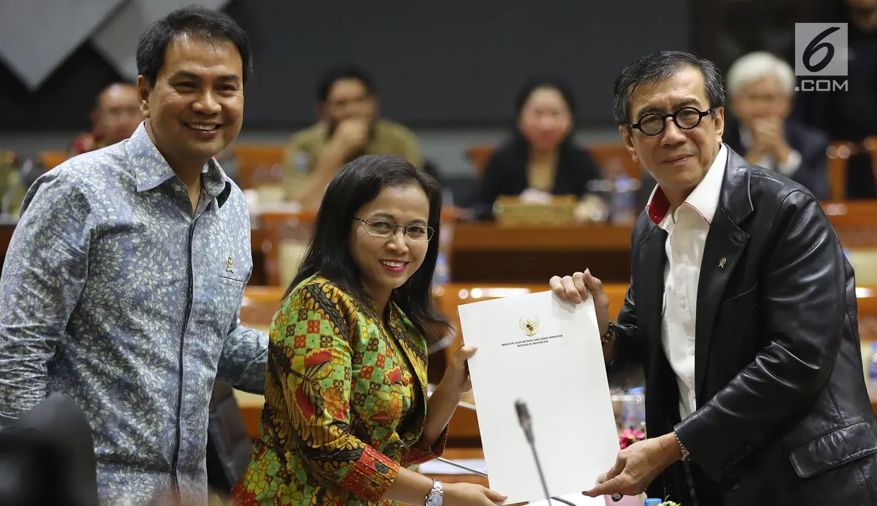 Menkumham Yasonna Laoly (kanan) menunjukkan dokumen saat rapat pleno terkait amnesti untuk Baiq Nuril dengan Komisi III DPR di Gedung Nusantara II, Jakarta, (24/7/2019). DPR setuju Presiden Joko Widodo atau Jokowi memberikan amnesti kepada Baiq Nuril. (Liputan6.com/JohanTallo)