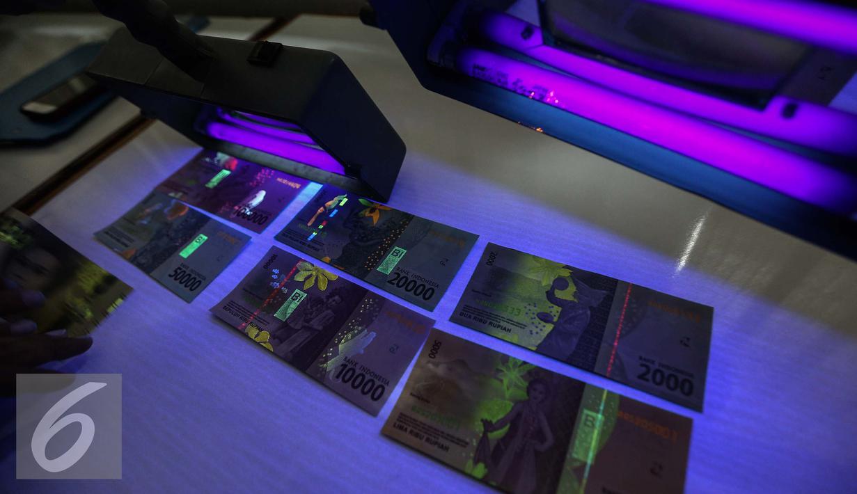 Gambar yang muncul saat uang kertas rupiah disinari lampu ultraviolet di kantor Peruri, Karawang, Jawa Barat, Rabu (18/1). Ada unsur pengaman yang mudah dapat diketahui masyarakat dan ada yang hanya bisa diketahui spesialis. (Liputan6.com/Faizal Fanani)