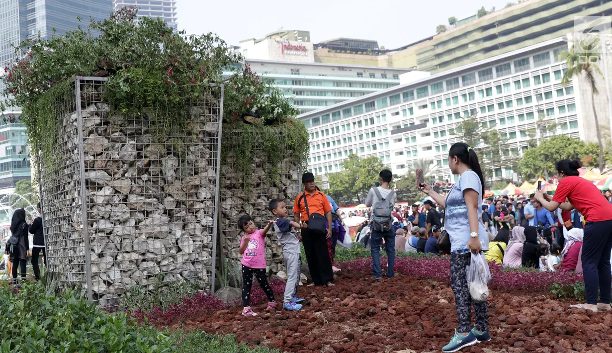 Anak-anak berfoto di area taman dekat Instalasi Gabion saat CFD di kawasan Bundaran Hotel Indonesia, Jakarta, Minggu (25/8/2019). Pengadaan Instalasi Gabion ini menggunakan Anggaran Pendapatan dan Belanja Daerah (APBD) Dinas Kehutanan DKI sebesar Rp 150 juta. (Liputan6.com/Helmi Fithriansyah)